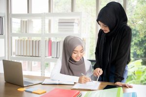 two-asian-muslim-businesswomen-talking-working-together-office-(edit)